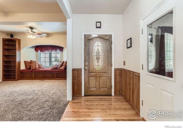 6544 Saddleback Ave, Longmont, CO 80504 - entrance foyer featuring wainscoting, ceiling fan, light wood-style flooring, and wood walls