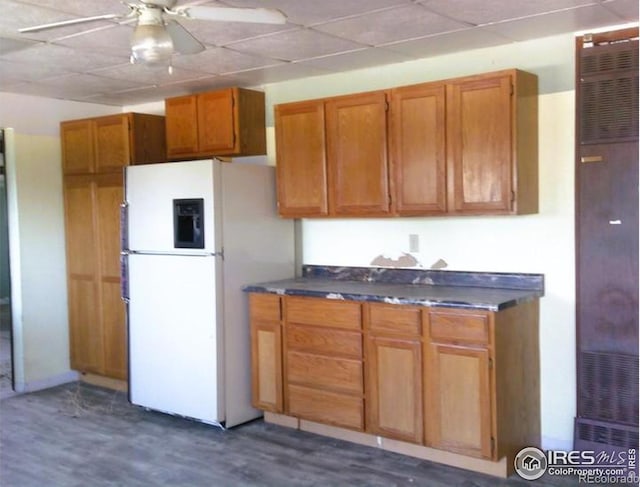 23243 Pawnee Ave, Padroni, CO 80745 - kitchen with white refrigerator with ice dispenser, a heating unit, ceiling fan, brown cabinets, and dark wood-style floors