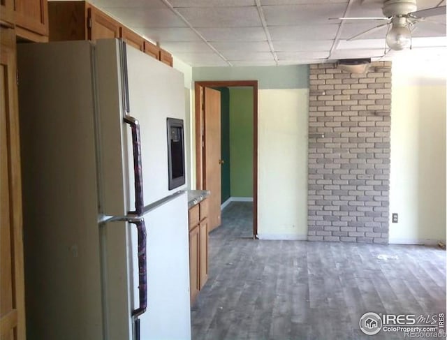 23243 Pawnee Ave, Padroni, CO 80745 - kitchen with freestanding refrigerator, brown cabinets, wood finished floors, a ceiling fan, and a drop ceiling