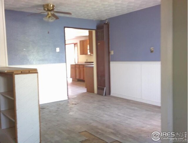 23243 Pawnee Ave, Padroni, CO 80745 - spare room with a wainscoted wall, a ceiling fan, and wood finished floors