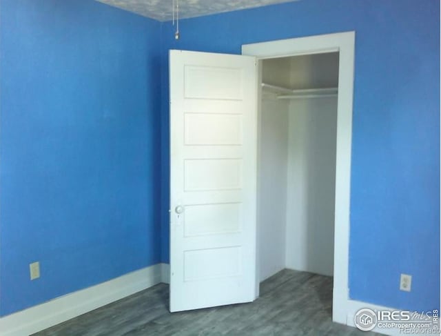 23243 Pawnee Ave, Padroni, CO 80745 - unfurnished bedroom featuring a closet and dark wood-style floors