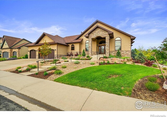 8406 Spinnaker Bay Dr, Windsor, CO 80528 - view of front of property with stone siding, stucco siding, an attached garage, driveway, and a front lawn