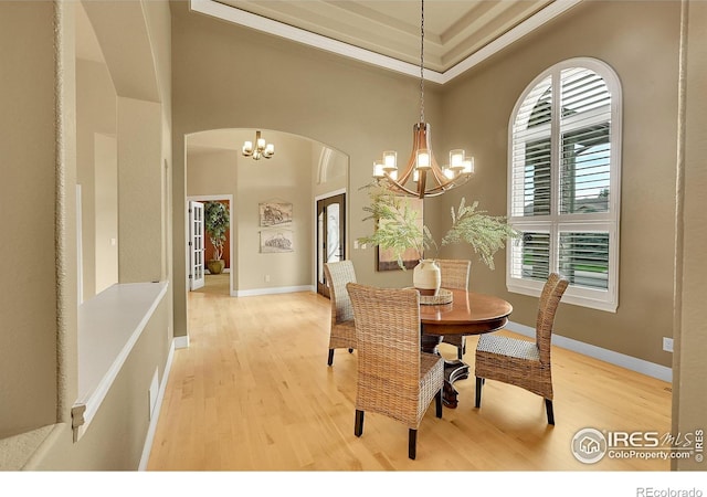 8406 Spinnaker Bay Dr, Windsor, CO 80528 - dining space featuring a chandelier, light wood-type flooring, arched walkways, and crown molding