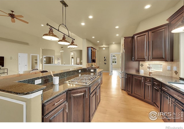 8406 Spinnaker Bay Dr, Windsor, CO 80528 - kitchen with appliances with stainless steel finishes, a ceiling fan, light wood finished floors, open floor plan, and dark brown cabinetry