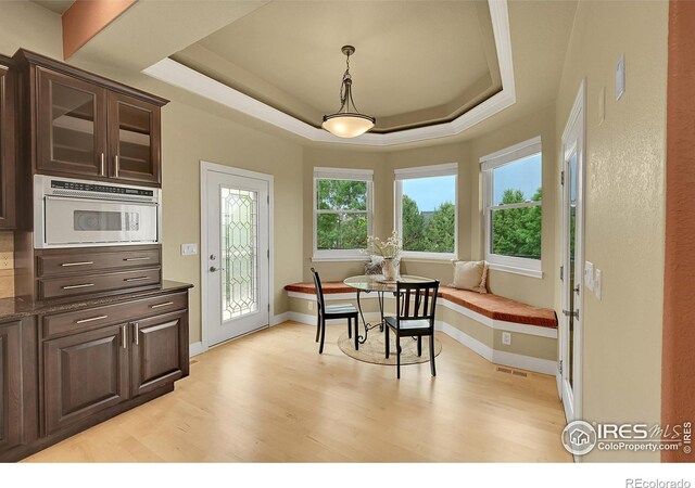 8406 Spinnaker Bay Dr, Windsor, CO 80528 - dining room with light wood-style flooring and a raised ceiling