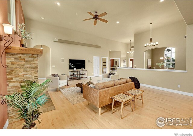 8406 Spinnaker Bay Dr, Windsor, CO 80528 - living room with light wood-type flooring, ceiling fan, a towering ceiling, a chandelier, and recessed lighting