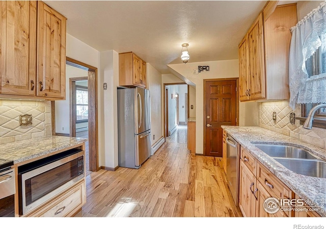 1906 Miner St, Idaho Springs, CO 80452 - kitchen with stainless steel appliances, light wood finished floors, tasteful backsplash, and a baseboard heating unit