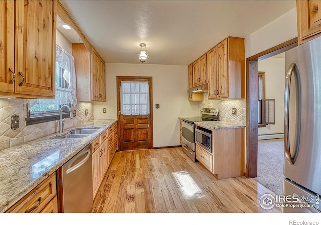 1906 Miner St, Idaho Springs, CO 80452 - kitchen with stainless steel appliances, light wood-style floors, light stone counters, tasteful backsplash, and under cabinet range hood