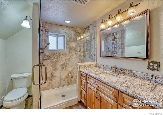 1906 Miner St, Idaho Springs, CO 80452 - bathroom featuring a stall shower, vanity, a textured ceiling, and wood finished floors