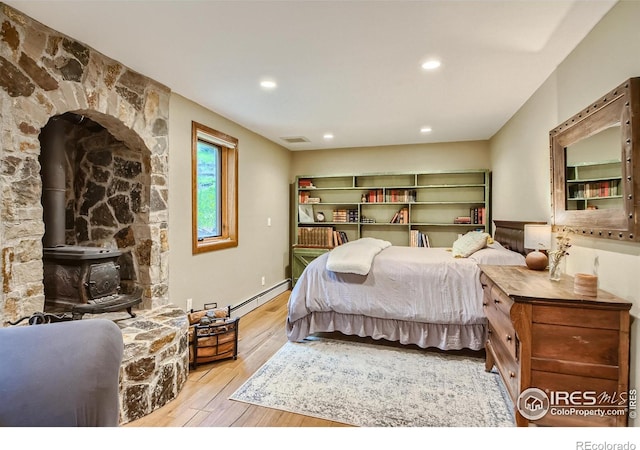 148 Granite Dr, Boulder, CO 80302 - bedroom with hardwood / wood-style flooring, a baseboard radiator, a wood stove, and recessed lighting