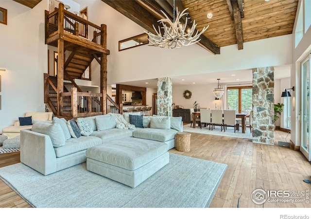 148 Granite Dr, Boulder, CO 80302 - living area with a chandelier, light wood finished floors, stairs, high vaulted ceiling, and a wooden ceiling with exposed beams