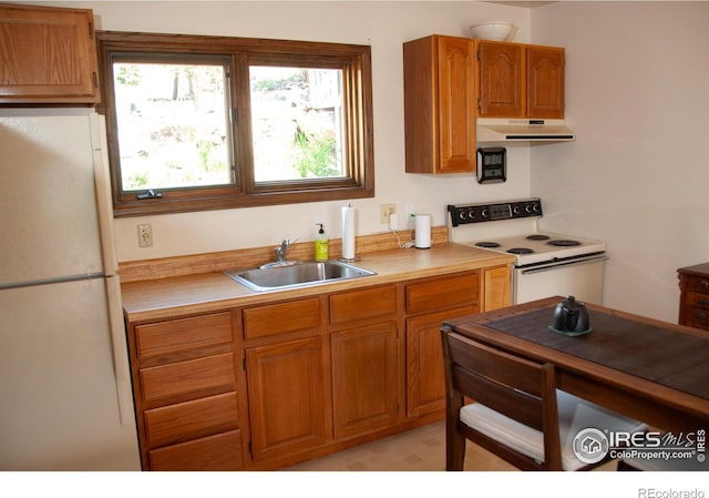 118 Alpine Dr, Estes Park, CO 80517 - kitchen with white appliances, under cabinet range hood, light countertops, and brown cabinetry