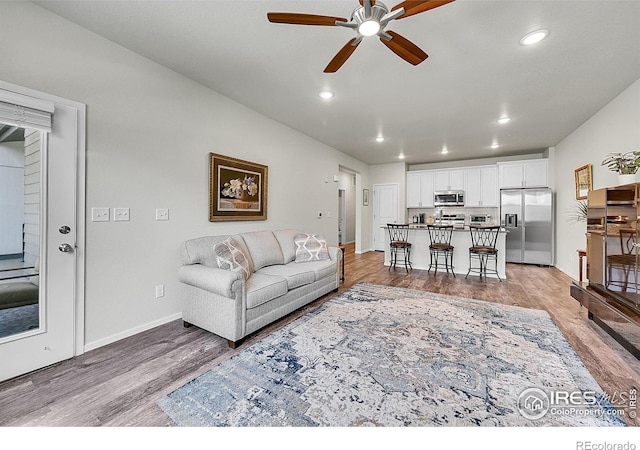 551 Vicot Way Unit D, Fort Collins, CO 80524 - living room with light wood finished floors, ceiling fan, and recessed lighting