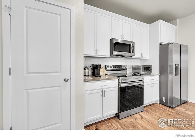 551 Vicot Way Unit D, Fort Collins, CO 80524 - kitchen with appliances with stainless steel finishes, light wood-style floors, white cabinetry, light countertops, and backsplash