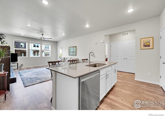 551 Vicot Way Unit D, Fort Collins, CO 80524 - kitchen with stainless steel dishwasher, light wood-type flooring, white cabinetry, ceiling fan, and a kitchen island with sink