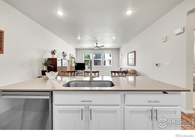 551 Vicot Way Unit D, Fort Collins, CO 80524 - kitchen featuring stainless steel dishwasher, open floor plan, white cabinetry, recessed lighting, and wood finished floors