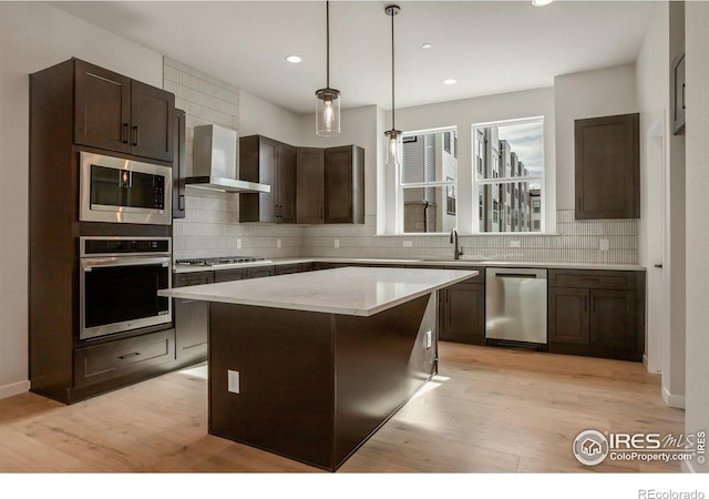 362 Promenade Dr, Superior, CO 80027 - kitchen with appliances with stainless steel finishes, tasteful backsplash, light wood-style flooring, dark brown cabinetry, and wall chimney exhaust hood