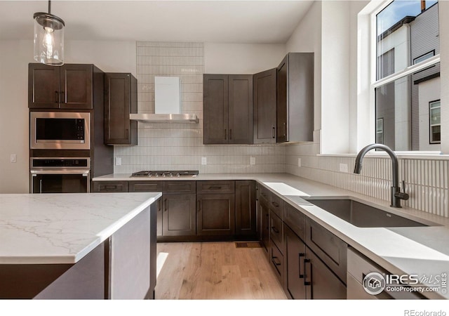 362 Promenade Dr, Superior, CO 80027 - kitchen featuring stainless steel appliances, light wood-style floors, dark brown cabinets, and tasteful backsplash