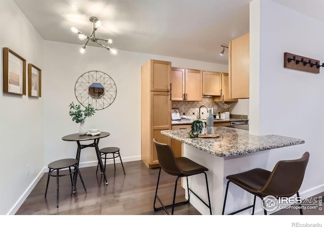 3250 Oneal Cir Unit 10, Boulder, CO 80301 - kitchen featuring a breakfast bar, a chandelier, backsplash, light brown cabinetry, and dark wood-style floors