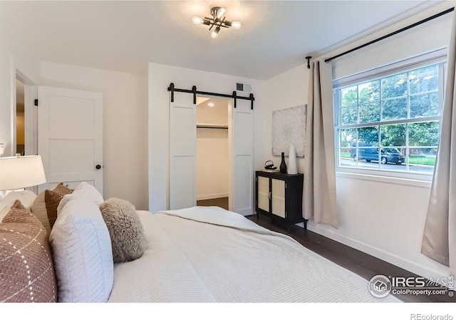 3250 Oneal Cir Unit 10, Boulder, CO 80301 - bedroom with a barn door, dark wood-style floors, a closet, and a walk in closet