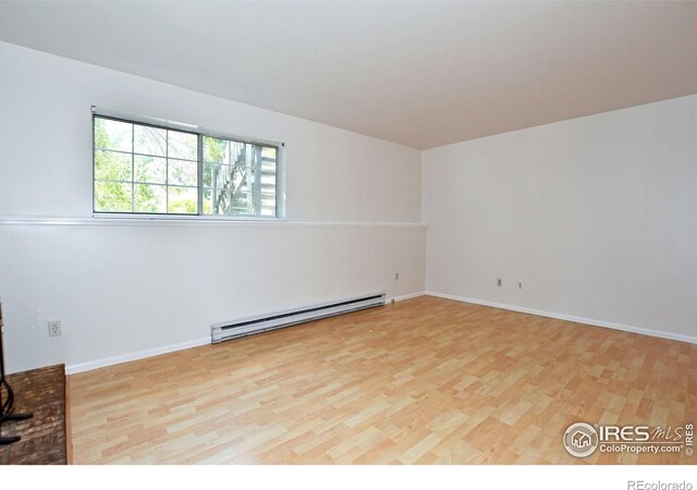 1601 W Swallow Rd Unit D, Fort Collins, CO 80526 - spare room featuring a baseboard radiator and light wood-type flooring