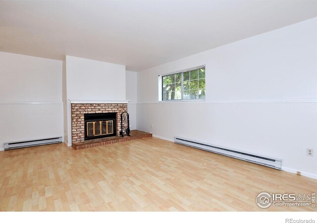 1601 W Swallow Rd Unit D, Fort Collins, CO 80526 - unfurnished living room with baseboard heating, wood finished floors, and a brick fireplace