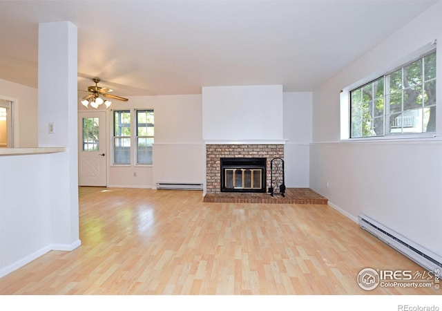 1601 W Swallow Rd Unit D, Fort Collins, CO 80526 - unfurnished living room featuring a baseboard radiator, light wood-type flooring, a brick fireplace, and ceiling fan