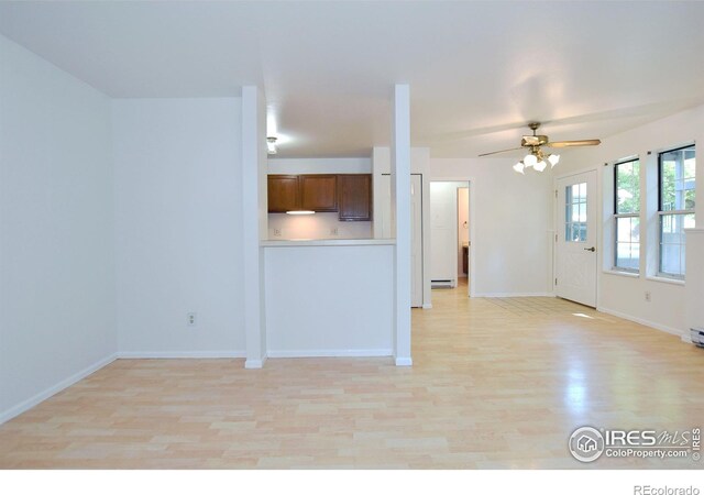 1601 W Swallow Rd Unit D, Fort Collins, CO 80526 - unfurnished living room with light wood-style floors, ceiling fan, and a baseboard heating unit