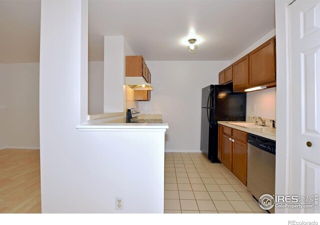 1601 W Swallow Rd Unit D, Fort Collins, CO 80526 - kitchen featuring dishwasher, premium range hood, brown cabinetry, light countertops, and freestanding refrigerator