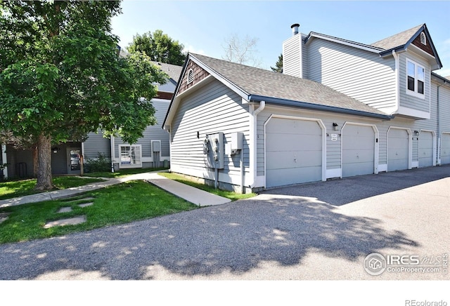 1601 W Swallow Rd Unit D, Fort Collins, CO 80526 - view of side of property with a chimney, roof with shingles, and a garage