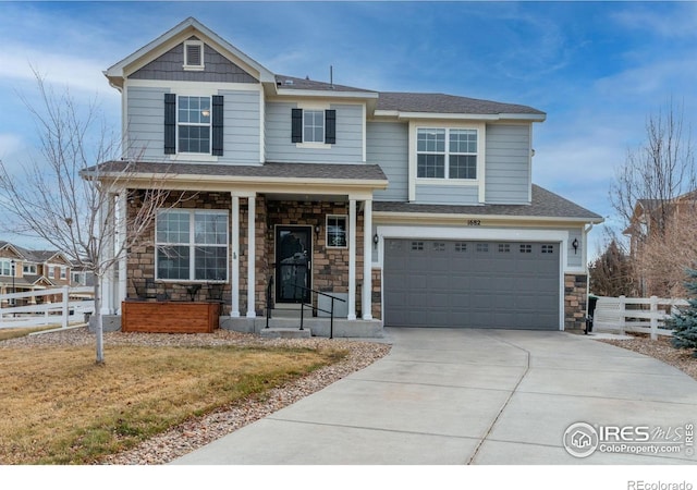 1682 Dorothy Cir, Longmont, CO 80503 - view of front of home with stone siding, a garage, concrete driveway, and roof with shingles