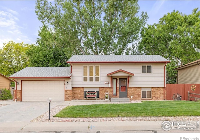 3207 Valmont St, Evans, CO 80620 - split foyer home featuring brick siding, driveway, an attached garage, and roof with shingles