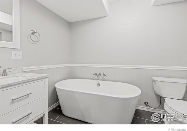 3207 Valmont St, Evans, CO 80620 - bathroom featuring vanity, wainscoting, and a freestanding bath