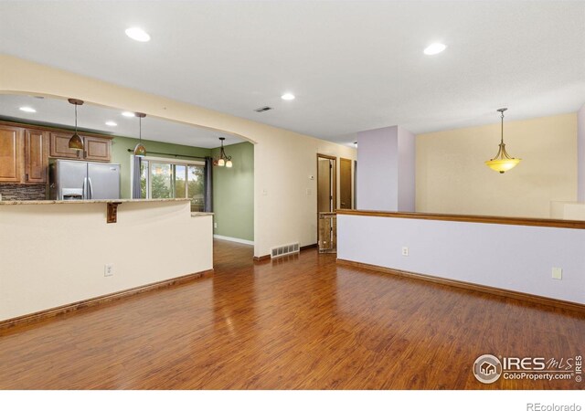 3207 Valmont St, Evans, CO 80620 - unfurnished living room featuring dark wood-style flooring, recessed lighting, and arched walkways