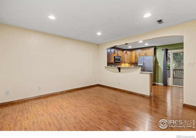 3207 Valmont St, Evans, CO 80620 - unfurnished living room with wood finished floors, arched walkways, and recessed lighting