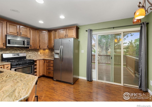 3207 Valmont St, Evans, CO 80620 - kitchen featuring stainless steel appliances, wood finished floors, backsplash, brown cabinets, and recessed lighting