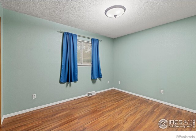 3207 Valmont St, Evans, CO 80620 - unfurnished room featuring wood finished floors and a textured ceiling
