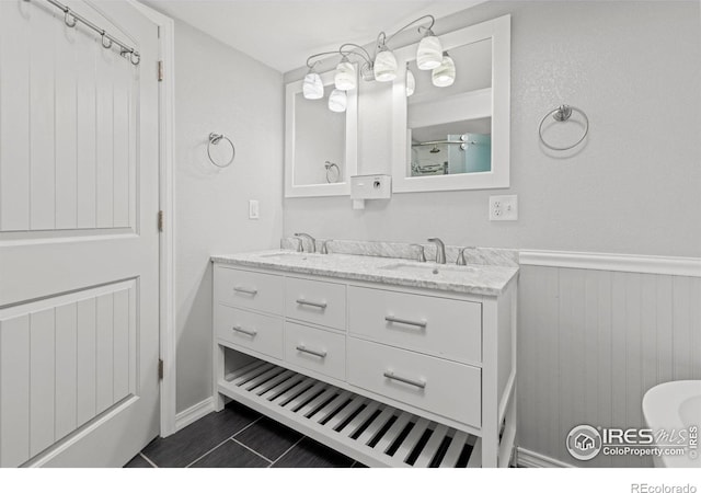 3207 Valmont St, Evans, CO 80620 - bathroom with double vanity, a wainscoted wall, and tile patterned floors