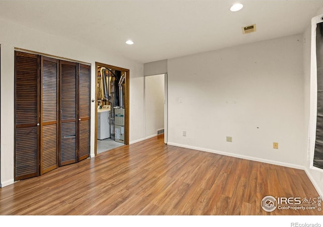 3207 Valmont St, Evans, CO 80620 - unfurnished bedroom featuring washer / clothes dryer, light wood-style floors, recessed lighting, and multiple closets