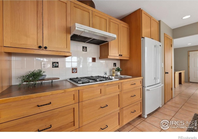 102 Bear Hollow Rd, Laporte, CO 80535 - kitchen featuring freestanding refrigerator, under cabinet range hood, gas stovetop, light tile patterned floors, and backsplash