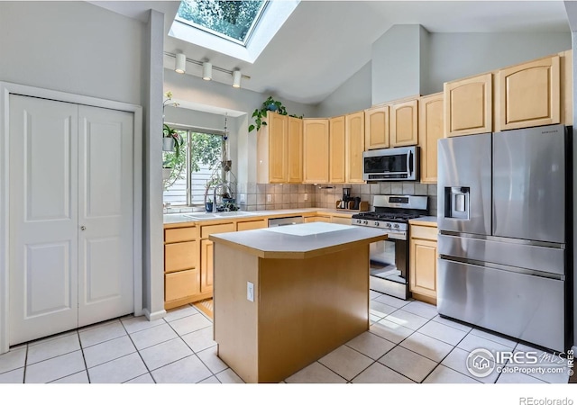 7196 Christopher Ct, Niwot, CO 80503 - kitchen with stainless steel appliances, light brown cabinets, a skylight, and vaulted ceiling