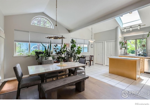 7196 Christopher Ct, Niwot, CO 80503 - dining room featuring a skylight, high vaulted ceiling, healthy amount of natural light, and light wood-style flooring
