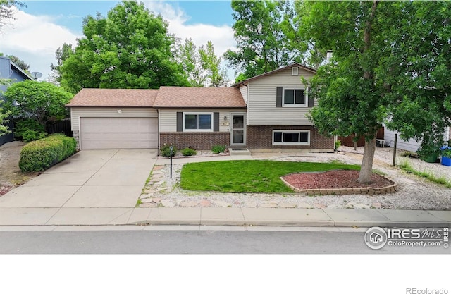 617 Cottonwood Dr, Loveland, CO 80538 - split level home featuring an attached garage, brick siding, concrete driveway, and a front lawn