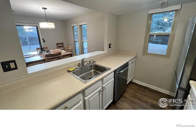 1141 Fairway Club Cir # C3, Estes Park, CO 80517 - kitchen with stainless steel dishwasher, dark wood finished floors, light countertops, and hanging light fixtures