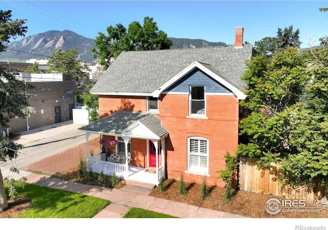 2025 18th St, Boulder, CO 80302 - view of front facade with a porch, a mountain view, brick siding, a chimney, and a shingled roof