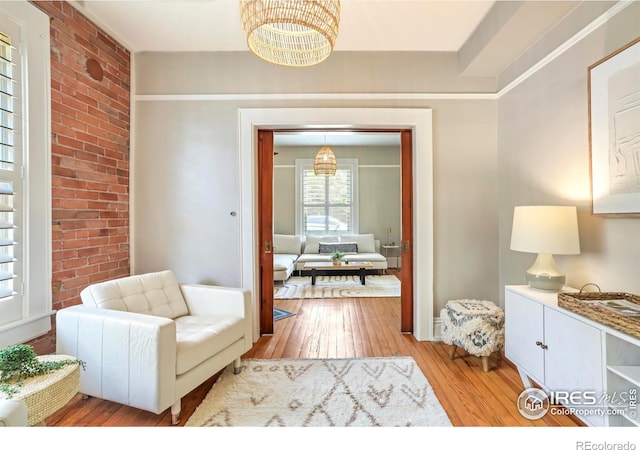 2025 18th St, Boulder, CO 80302 - sitting room featuring light wood-style flooring, a chandelier, and brick wall