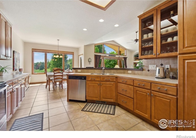 2156 Meander Rd, Windsor, CO 80550 - kitchen featuring stainless steel appliances, backsplash, a peninsula, brown cabinets, and vaulted ceiling