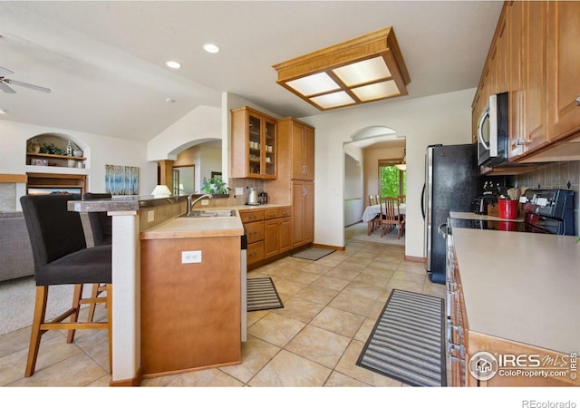 2156 Meander Rd, Windsor, CO 80550 - kitchen with arched walkways, appliances with stainless steel finishes, a breakfast bar area, decorative backsplash, and ceiling fan