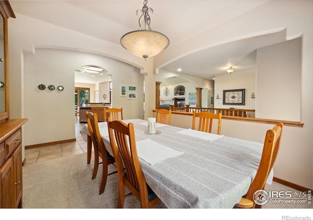 2156 Meander Rd, Windsor, CO 80550 - dining room with decorative columns, arched walkways, light carpet, and light tile patterned flooring