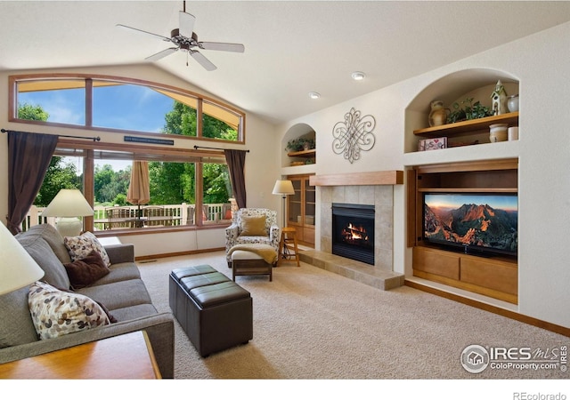 2156 Meander Rd, Windsor, CO 80550 - living area with carpet floors, a tiled fireplace, vaulted ceiling, a ceiling fan, and built in shelves